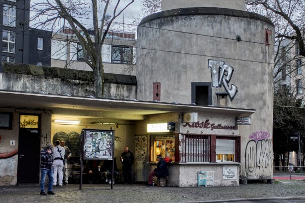 People gather at a former water house, a small shop that sprung up in the 19th century to encourage workers to drink affordable water rather than beer or schnapps, that is now a kiosk in Frankfurt, Germany, on March 31, 2025. (AP Photo/Michael Probst)