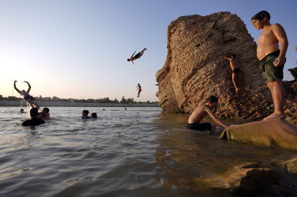 Iraqis swim in the Tigris River in Baghdad, Iraq, Thursday, July 13, 2023. (AP Photo/Hadi Mizban)