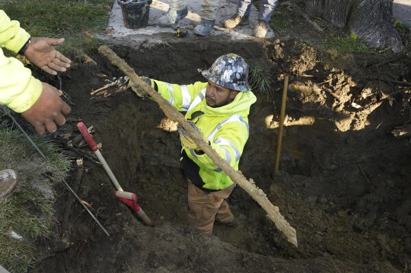 FILE - A cut lead pipe is pulled from a dig site for testing at a home in Royal Oak, Mich., on Nov. 16, 2021. The Environmental Protection Agency will soon strengthen lead in drinking water regulations. (AP Photo/Carlos Osorio, File)