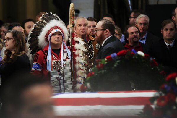 
              Native Americans Donald Woody, left, and Warren Stade of the Shakopee Mdewakanton Sioux Community tribe in Prior Lake, Minn., pay their last respects to former President George H.W. Bush as he lies in state at the U.S. Capitol in Washington, Tuesday, Dec. 4, 2018. (AP Photo/Manuel Balce Ceneta)
            