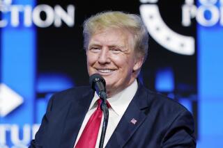 FILE - Former President Donald Trump smiles as he pauses while speaking to supporters at a Turning Point Action gathering in Phoenix, July 24, 2021.  Trump is slamming politicians who refuse to say whether they’ve received COVID-19 booster shots, calling them “gutless.” In an interview with One America News Network on Tuesday night, he said unnamed politicians have been afraid to admit they got the booster shot.  (AP Photo/Ross D. Franklin, File)