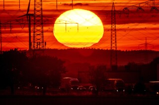 FILE - The sun rises above a highway in Frankfurt, Germany, Aug. 2, 2022. Former NASA top scientist James Hansen is warning that global warming is accelerating faster than most models are showing, a contention that other scientists think is overblown. He argues that since 2010 there is more sun energy in the atmosphere, and less of the particles that can reflect it back into space thanks to efforts to cut pollution. (AP Photo/Michael Probst, File)