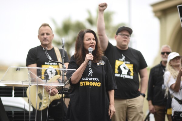 SAG-AFTRA President Fran Drescher, center, speaks during a rally outside Paramount Pictures Studio on Wednesday, Sept. 13, 2023, in Los Angeles. The film and television industries remain paralyzed by Hollywood's dual actors and screenwriters strikes. (Photo by Richard Shotwell/Invision/AP)