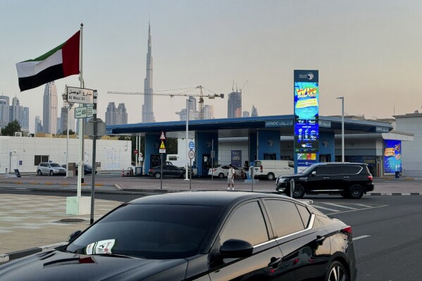 Cars pass by an Abu Dhabi National Oil Co. (ADNOC) gas station with the Burj Khalifa, the world’s tallest building, in background, in Dubai, United Arab Emirates, Saturday, Nov. 4, 2023. (AP Photo/Kamran Jebreili)