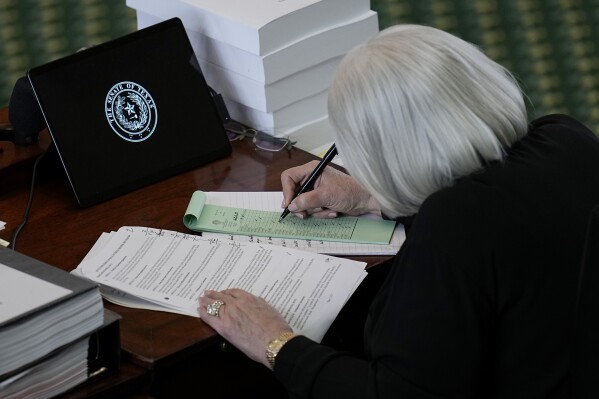 Texas state Sen. Judith Zaffirini, right, acting as a juror track voting on the articles of impeachment against suspended Texas Attorney General Ken Paxton in the Senate Chamber at the Texas Capitol, Saturday, Sept. 16, 2023, in Austin, Texas. (AP Photo/Eric Gay)
