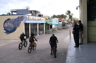 Hollywood police patrol near the scene of a shooting along the Hollywood Boardwalk, Tuesday, May 30, 2023, in Hollywood, Fla. Some social media users are connecting the Memorial Day shooting to a bill signed in April allowing concealed carry without a government permit. But the law does not go into effect until July. (AP Photo/Lynne Sladky)