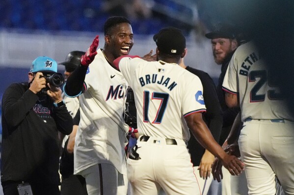 Miami Marlins' Jesús Sánchez, left is congratulated by Vidal Bruján (17) after Sanchez's hit led to the winning run during the 10 inning a baseball game against the Colorado Rockies, Thursday, May 2, 2024, in Miami. The Marlins defeated the Rockies 5-4. (AP Photo/Marta Lavandier)