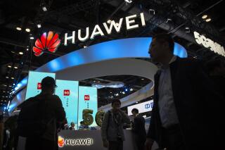 FILE - In this Oct. 31, 2019, file photo, attendees walk past a display for 5G services from Chinese technology firm Huawei at the PT Expo in Beijing. A federal appeals court refused Friday, June 18, 2021 to hear Chinese tech giant Huawei's request to throw out a rule used to bar rural phone carriers on national security grounds from using government funds to purchase its equipment. (AP Photo/Mark Schiefelbein, File)