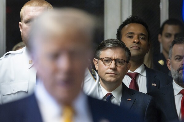 U.S. Speaker of the House Mike Johnson, center, and businessman Vivek Ramaswamy listen as former President Donald Trump, left, talks with reporters as he arrives at Manhattan criminal court in New York, on Tuesday, May 14, 2024. (Justin Lane/Pool Photo via AP)