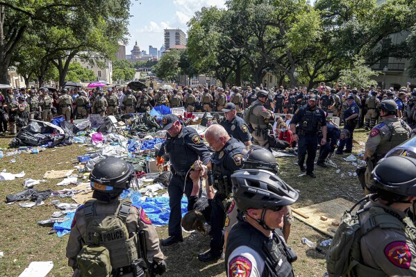 Protestujący jest eskortowany przez policję Uniwersytetu Teksasu w Austin w obozie na terenie kampusu, poniedziałek, 29 kwietnia 2024 r.  (Aaron E. Martinez/Austin American-Statesman za pośrednictwem AP)