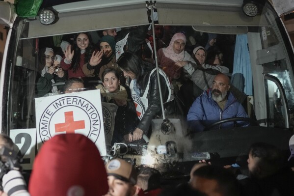 Palestinian female prisoners, who were released from an Israeli prison as part of a ceasefire deal between Israel and Hamas, wave from inside a bus as they arrive in the West Bank city of Beitunia, Monday, Jan. 20, 2025. (AP Photo/Leo Correa, File)