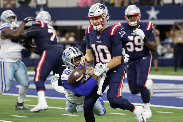 Dallas Cowboys defensive end Dante Fowler Jr. (56) strips the ball away from New England Patriots quarterback Mac Jones (10) in the first half of an NFL football game in Arlington, Texas, Sunday, Oct. 1, 2023. The fumble was recovered by linebacker Leighton Vander Esch and returned for a touchdown. (AP Photo/Michael Ainsworth)