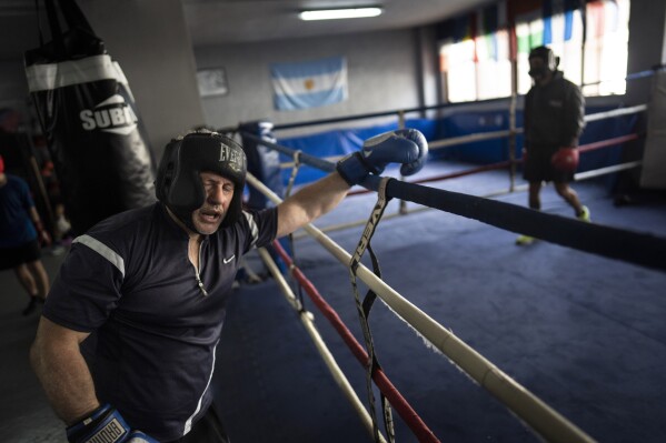 A boxing hobbyist leans on a rope ring after an intense training session in the Platense sports facility soccer club in Buenos Aires, Argentina, Friday, Nov. 17, 2023. (AP Photo/Rodrigo Abd)