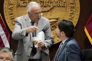 FILE - Rep. Bud Hulsey, R-Kingsport, left, talks with Rep. Andrew Farmer, R-Sevierville, before a meeting of the COVID-19 Committee, Oct. 28, 2021, in Nashville, Tenn. The first month back at the state Capitol has felt frustratingly familiar for Black lawmakers in Tennessee’s majority-white Legislature. First, lawmakers passed a new congressional map scattering Nashville’s Black voters across multiple districts. Now, Hulsey wants to advance a resolution dismissing the existence of deep-rooted racism in the military as detailed in an Associated Press investigation. (AP Photo/Mark Humphrey, FILE)