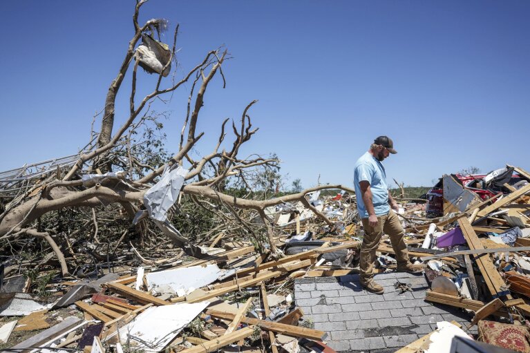Paden Fincher looks to salvage items from what's left of his sister's home following a severe storm, Tuesday, May 7, 2024 in Barnsdall, Okla. Fincher said his sister, her husband and their 3 children rode the storm out in the home. He said his sister was in surgery, but said she was going to be ok. A tornado destroyed homes, forced the evacuation of a nursing home and toppled trees and power lines when it roared through the small Oklahoma town. (Mike Simons/Tulsa World via AP)