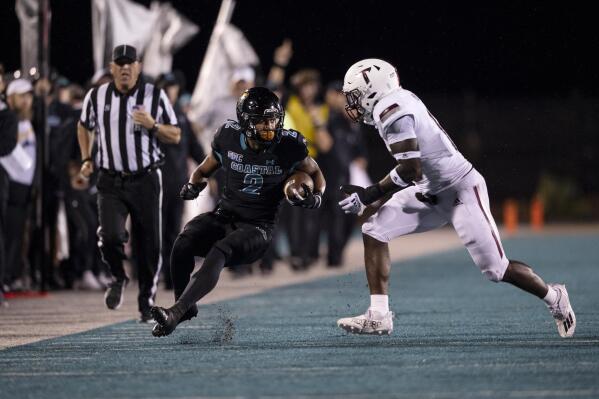 Coastal Carolina running back Reese White (2) avoids a tackle from Troy cornerback Elijah Culp (1) during the first half of an NCAA college football game Thursday, Oct. 28, 2021, in Conway, S.C. (AP Photo/Matt Kelley)