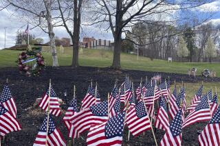 FILE - Flags and wreaths honor veterans on the grounds of the Soldiers' Home in Holyoke, April 28, 2020, where a number of people died due to COVID-19, in Holyoke, Mass. Massachusetts has agreed to pay $56 million to settle a class-action lawsuit brought by the families of veterans who died or became sick after contracting COVID-19 at the state-run veterans' care center during one of the deadliest outbreaks at a long-term care facility in the U.S., officials said Thursday, May 12, 2022. (AP Photo/Rodrique Ngowi, File)