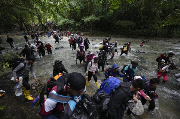 FILE - Migrants cross a river during their journey through the Darien Gap from Colombia into Panama, hoping to reach the U.S., Oct. 15, 2022. President-elect José Raúl Mulino said Thursday, May 9, 2024, he will shut down the migration route used by more than 500,000 people last year. Until now, Panama has helped speedily bus the migrants across its territory so they can continue their journey north. (AP Photo/Fernando Vergara, File)