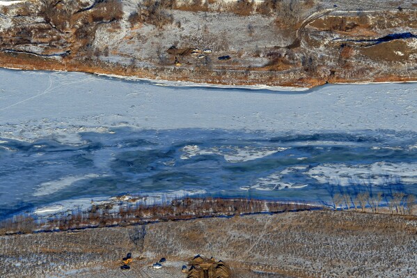 FILE - Photo crews work to contain an oil spill from Bridger Pipeline's broken pipeline near Glendive, Mont., on Jan. 19, 2015, in this aerial view showing both sides of the river. The U.S. Environmental Protection Agency on Monday, July 31, 2023, announced the settlement in a 2022 federal court lawsuit. Belle Fourche Pipeline Company and Bridger Pipeline LLC will pay the $12.5 million to resolve the claims made under the Clean Water Act and Pipeline Safety Laws, EPA said. (Larry Mayer/The Billings Gazette via AP, File)