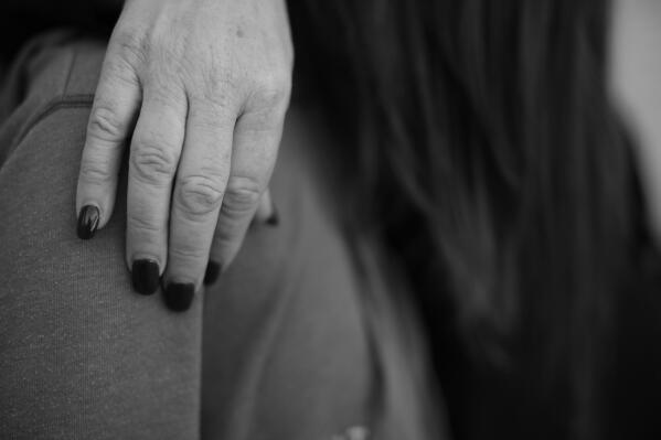 In this Oct. 27, 2021 photo, MJ’s adoptive mother put her hand over MJ's shoulder at their home. (AP Photo/Dario Lopez-Mills)

