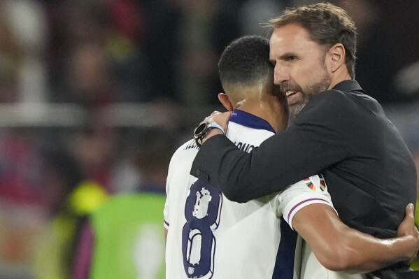 England's manager Gareth Southgate, right, hugs England's Trent Alexander-Arnold during a Group C match between Serbia and England at the Euro 2024 soccer tournament in Gelsenkirchen, Germany, Sunday, June 16, 2024. (AP Photo/Martin Meissner)