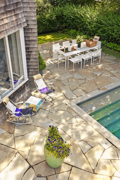 This photo provided by Rottet Studio shows a backyard designed by architect and interior designer Lauren Rottet in Montauk, N.Y. To add color and a lovely scent, Rottet recommends adding a large planter filled with flowering plants, as she did here in this backyard. (Eric Laignel/Rottet Studio via AP)