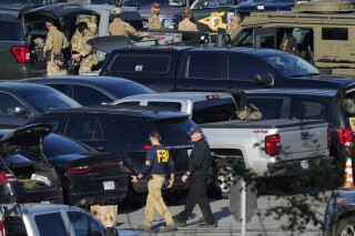 Law enforcement personnel are staged in a school parking lot during a manhunt for Robert Card in the aftermath of a mass shooting in Lewiston, Maine, Oct. 27, 2023. (AP Photo/Matt Rourke, File)