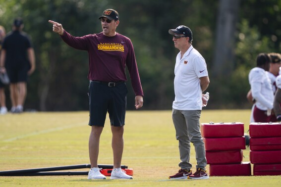 Washington Commanders head coach Ron Rivera, left, talks with owner Josh Harris during an NFL football practice at the team's training facility, Wednesday, Aug. 2, 2023, in Ashburn, Va. (AP Photo/Evan Vucci)