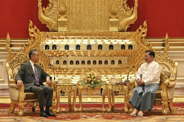 This photo provided by Myanmar Military Information Team, Myanmar's military leader Senior Gen. Min Aung Hlaing, right, chairman of State Administration Council, talks with Chinese Foreign Minister Wang Yi, during their meeting Wednesday, Aug. 14, 2024, in Naypyitaw, Myanmar. (Myanmar Military Information Team via AP)