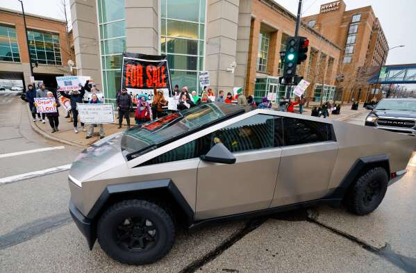 Protesters shout at a Tesla Cybertruck before a town hall with Elon Musk, Sunday, March 30, 2025, in Green Bay, Wis. (AP Photo/Jeffrey Phelps)