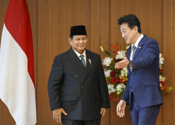 Indonesian Defense Minister and President-elect Prabowo Subianto, left, is shown the seat for talks by Japanese counterpart Minoru Kihara, right, at the Defense Ministry in Tokyo, Japan, Wednesday, April 3, 2024. (Kimimasa Mayama/Pool Photo via AP)