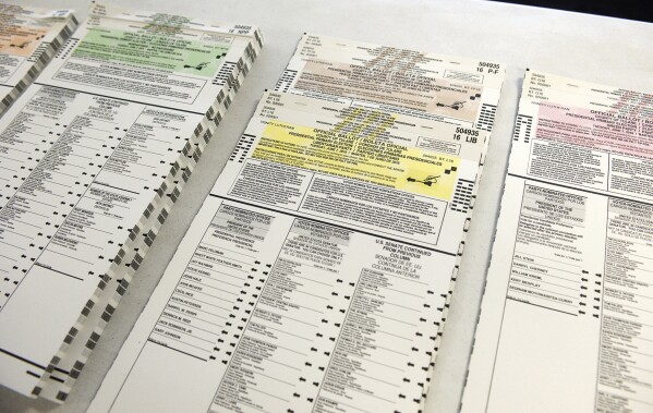 FILE - Colored coordinated Presidential Primary Election ballots are organized by political parties for voters on June 7, 2016, at Trinity Lutheran Church in Porterville, Calif. While the politics are murky, the fresh frenzy of outsider candidates threatens to weaken both major parties as President Joe Biden and Republican Donald Trump tighten their grip on their party's presidential nominations. There’s little concern that the independent or third-party candidates would actually win the presidency, but they could siphon support from the ultimate Democratic and Republican nominees. (Chieko Hara/The Porterville Recorder via AP, File)