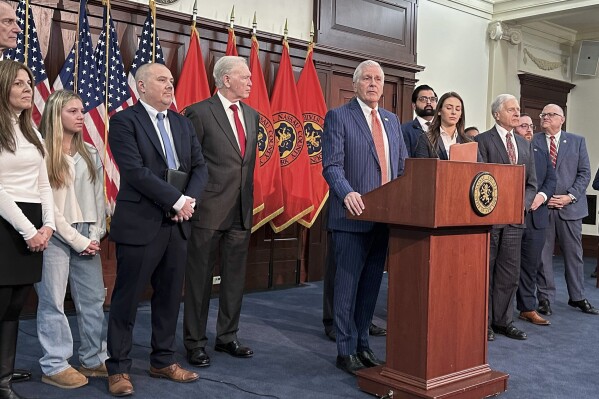 Nassau County Executive Bruce Blakeman, at podium, speaks during a news conference in Mineola, N.Y., Wednesday, March 6, 2024. The Republican official in New York City's suburbs, who prohibited transgender athletes from participating in girls and women's sports competitions, has asked a federal court to affirm that he has the power to implement the ban. (AP Photo/Philip Marcelo)