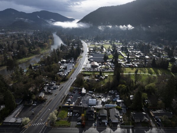 Vehicles drive down Rogue River Highway as light shines on the area March 23, 2024, in Grants Pass, Ore. (AP Photo/Jenny Kane, File)