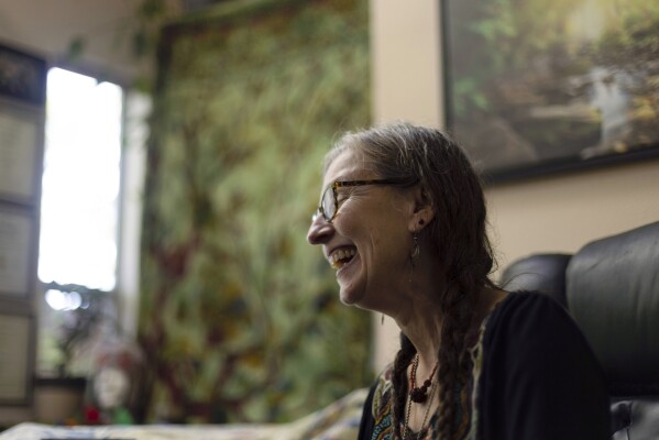 Cathy Jonas, owner of Epic Healing Eugene, laughs during an interview on Friday, Aug. 4, 2023, in Eugene, Ore. Epic Healing Eugene, Oregon’s first licensed psilocybin service center, opened in June, marking the state’s unprecedented step in offering the mind-bending drug to the public. Jonas said she doesn't expect her service center to start making money for a while. Providing legal access to psychedelic mushrooms is a calling, she said: “The plant medicines have communicated to me that I’m supposed to be doing this thing." (AP Photo/Jenny Kane)