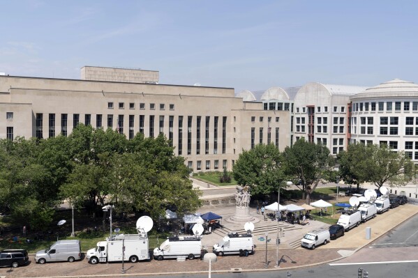 Television news crews set up outside federal court in Washington, on Thursday, July 27, 2023, where a grand jury has been meeting in the probe led by special counsel Jack Smith against former President Donald Trump. (AP Photo/Jose Luis Magana)