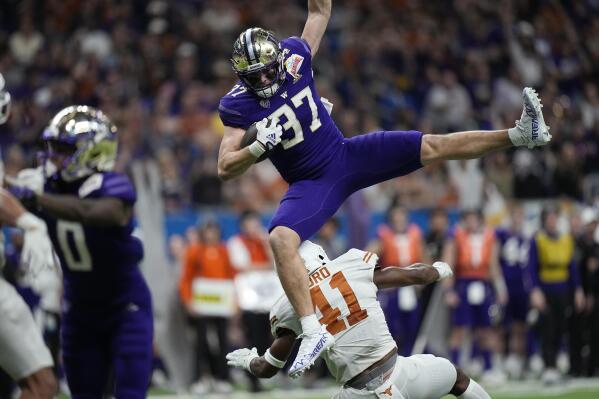 Washington tight end Jack Westover (37) is upended by Texas linebacker Jaylan Ford (41) after making a catch during the second half of the Alamo Bowl NCAA college football game in San Antonio, Thursday, Dec. 29, 2022. (AP Photo/Eric Gay)