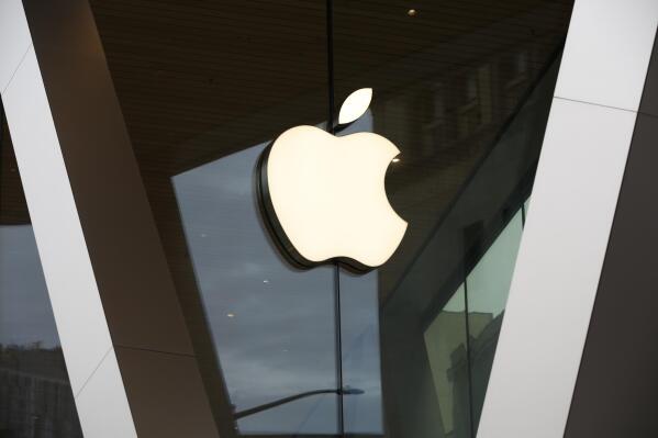 FILE - In this Saturday, March 14, 2020 file photo, an Apple logo adorns the facade of the downtown Brooklyn Apple store in New York.  Apple is heading into a trial that threatens to upend the app store that brings in billions of dollars each year while feeding the more than 1.6 billion iPhones, iPads, and other devices at the core of its digital empire. The federal court case is being brought by Epic Games, the maker of the popular video Fortnite video game, in an attempt to topple the so-called “walled garden” that Apple has painstakingly built around its products. (AP Photo/Kathy Willens, File)