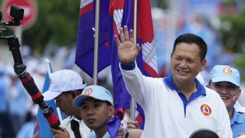 Hun Manet, vorne rechts, ein Sohn des kambodschanischen Premierministers Hun Sen, winkt aus einem Fahrzeug, als er am Freitag, den 21. Juli 2023, in Phnom Penh, Kambodscha, eine Prozession zum Ende eines Wahlkampfs der Kambodschanischen Volkspartei anführt. Hun Sen sagt, er sei bereit, das Amt des Premierministers an seinen ältesten Sohn, Hun Manet, zu übergeben, der die Armee des Landes leitet.  (AP Photo/Heng Sinith)