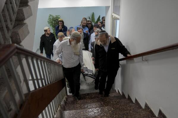 Mourners carry the body of rabbi Haim Drukman during his funeral in Merkaz Shapira, a village in southern Israel, Monday, Dec. 26, 2022. Haim Drukman, a prominent rabbi who was one of the founders of Israel's settlement movement, and a former member of Knesset, Israel's parliament, died Sunday. He was 90. Drukman was a leading figure in the religious Zionist movement in Israel, and a major proponent of Jewish settlements in the West Bank, the Gaza Strip and the Sinai Peninsula after Israel captured those territories in the 1967 Mideast war. (AP Photo/Tsafrir Abayov)