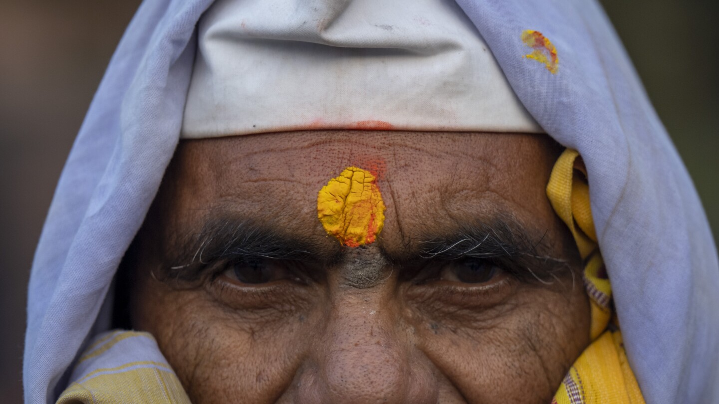 An Indian pilgrim who is embarked on a visit to the sacred Pashupatinath temple poses for a photograph in Kathmandu, Nepal, Jan. 12, 2024. The centuries-old temple is one of the most important pilgrimage sites in Asia for Hindus.Nepal and India are the world’s two Hindu-majority nations and share a strong religious affinity. Every year, millions of Nepalese and Indians visit Hindu shrines in both countries to pray for success and the well-being of their loved ones. (AP Photo/Niranjan Shrestha)