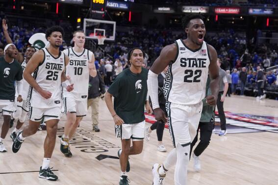 Michigan State center Mady Sissoko (22) and teammates celebrate their overtime win over Kentucky in an NCAA college basketball game, Tuesday, Nov. 15, 2022, in Indianapolis. (AP Photo/Darron Cummings)