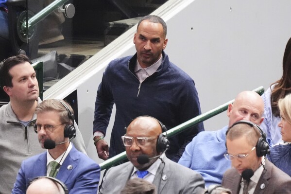 Nico Harrison, center rear, the Dallas Mavericks general manager watches the team play against the Toronto Raptors in the second half of an NBA basketball game in Dallas, Friday, April 11, 2025. (AP Photo/LM Otero)