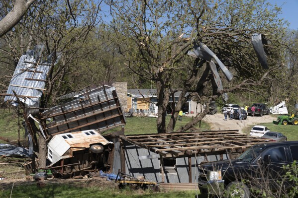 Metal sidings are throw up in trees on Ethan Steenbach's property Tuesday morning, April 16, 2024, in Overbrook, Kan., following a tornado that hit the area. Strong storms have caused damage in parts of the middle U.S. and spawned tornadoes in Kansas and Iowa. (Evert Nelson/The Topeka Capital-Journal via AP)