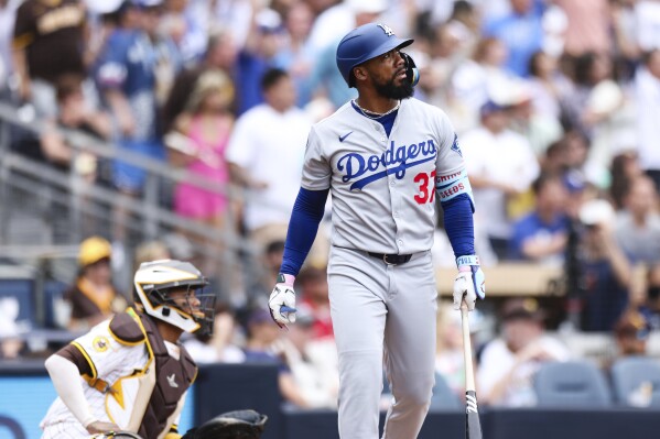 Los Angeles Dodgers' Teoscar Hernandez, right, watches his three-run home run as San Diego Padres' Martin Maldonado looks on in the sixth inning of a baseball game Wednesday, June 11, 2025, in San Diego. (AP Photo/Derrick Tuskan)