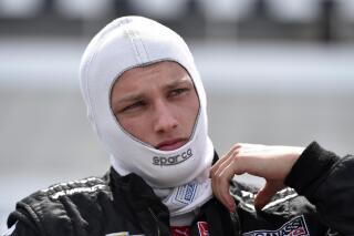 FILE - Sage Karam stands on pit road during qualifying for the Pocono IndyCar 500 auto race, in Long Pond, Pa., Aug. 22, 2015. Karam's somber reality at Pocono Raceway is this: Racing can be such a fatal-and-harrowing sport. Karam triggered a wreck in his last race at the tri-oval track that killed an IndyCar driver and sunk him so deep into a depression that he doubted he would compete again.. (AP Photo/Derik Hamilton, File)