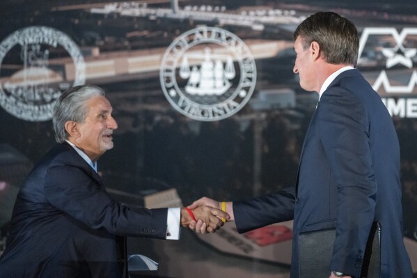 FILE - Ted Leonsis, left, owner of the Washington Wizards NBA basketball team and the Washington Capitals NHL hockey team, shakes hands with Virginia Gov. Glenn Youngkin as they announce plans for a new sports stadium for the teams, Dec. 13, 2023, in Alexandria, Va. Legislation underpinning a plan to relocate the Wizards and the Capitals across the Potomac River to northern Virginia easily cleared an early hurdle in the state Legislature, Friday, Feb. 9, 2024. (AP Photo/Alex Brandon, File)