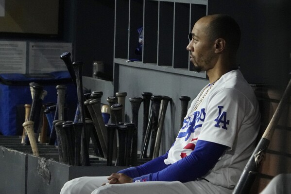 Los Angeles Dodgers' Mookie Betts watches from the dugout during the eighth inning in Game 2 of a baseball NL Division Series against the Arizona Diamondbacks, Monday, Oct. 9, 2023, in Los Angeles. (AP Photo/Mark J. Terrill)