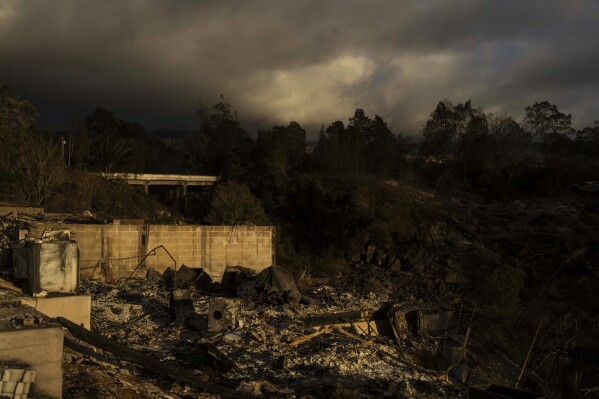 FILE - Clouds hang over a home destroyed in a wildfire in Kula, Hawaii, Tuesday, Aug. 15, 2023. The Maui Fire Department is expected to release a report Tuesday, April 16, 2024, detailing how the agency responded to a series of wildfires that burned on the island during a windstorm last August. (AP Photo/Jae C. Hong, File)