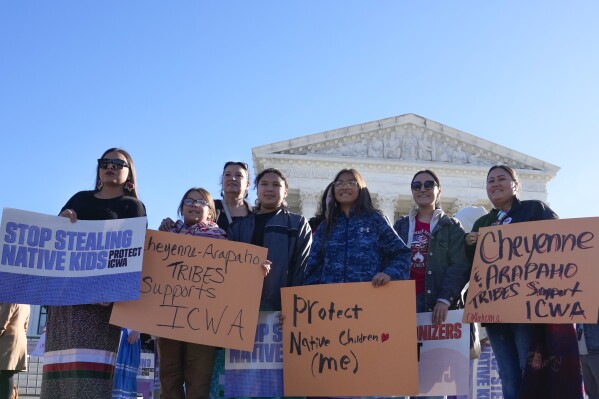 FILE- Demonstrators stand outside of the U.S. Supreme Court, as the court hears arguments over the Indian Child Welfare Act, Nov. 9, 2022, in Washington. The Supreme Court on Thursday, June 15, 2023, preserved the 1978 Indian Child Welfare Act, which gives preference to Native American families in foster care and adoption proceedings of Native children, rejecting a broad attack from Republican-led states and white families who argued it is based on race. (AP Photo/Mariam Zuhaib, File)